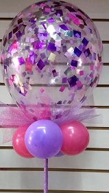 Clear confetti pink and purple balloon with small pink purple balloons on stick covered with net