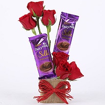 6 red roses with 2 Small Silk Chocolates in a basket tied with red ribbons